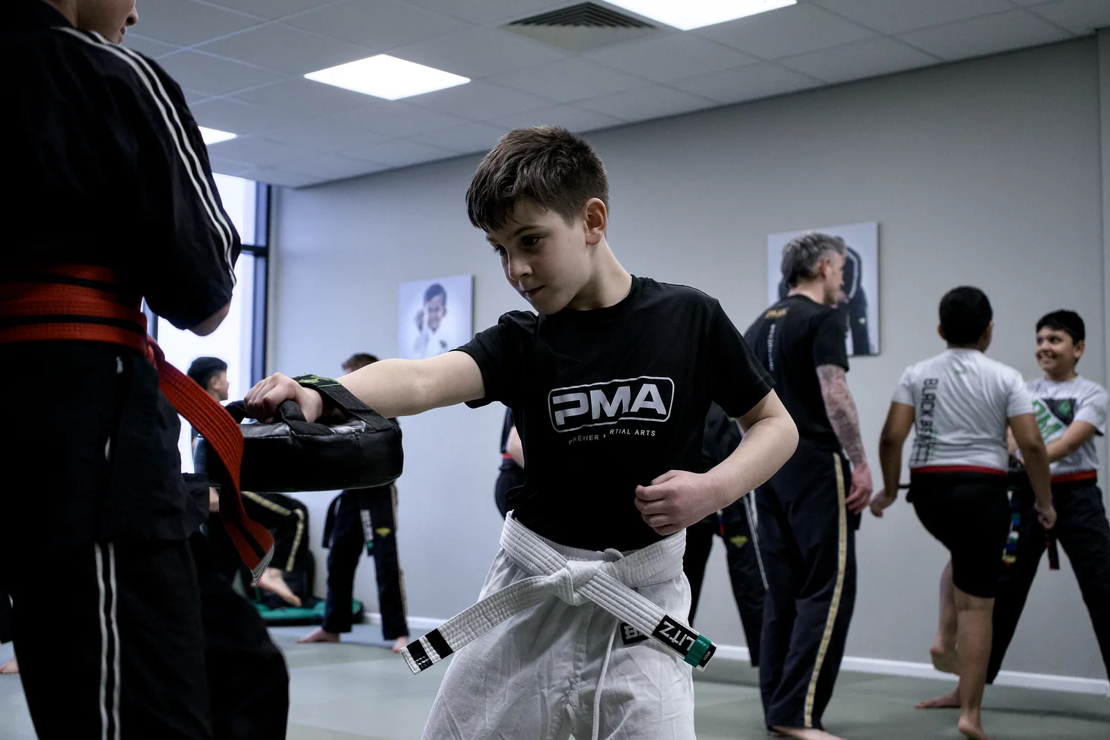 A boy watching the instructor closely, adjusting his stance