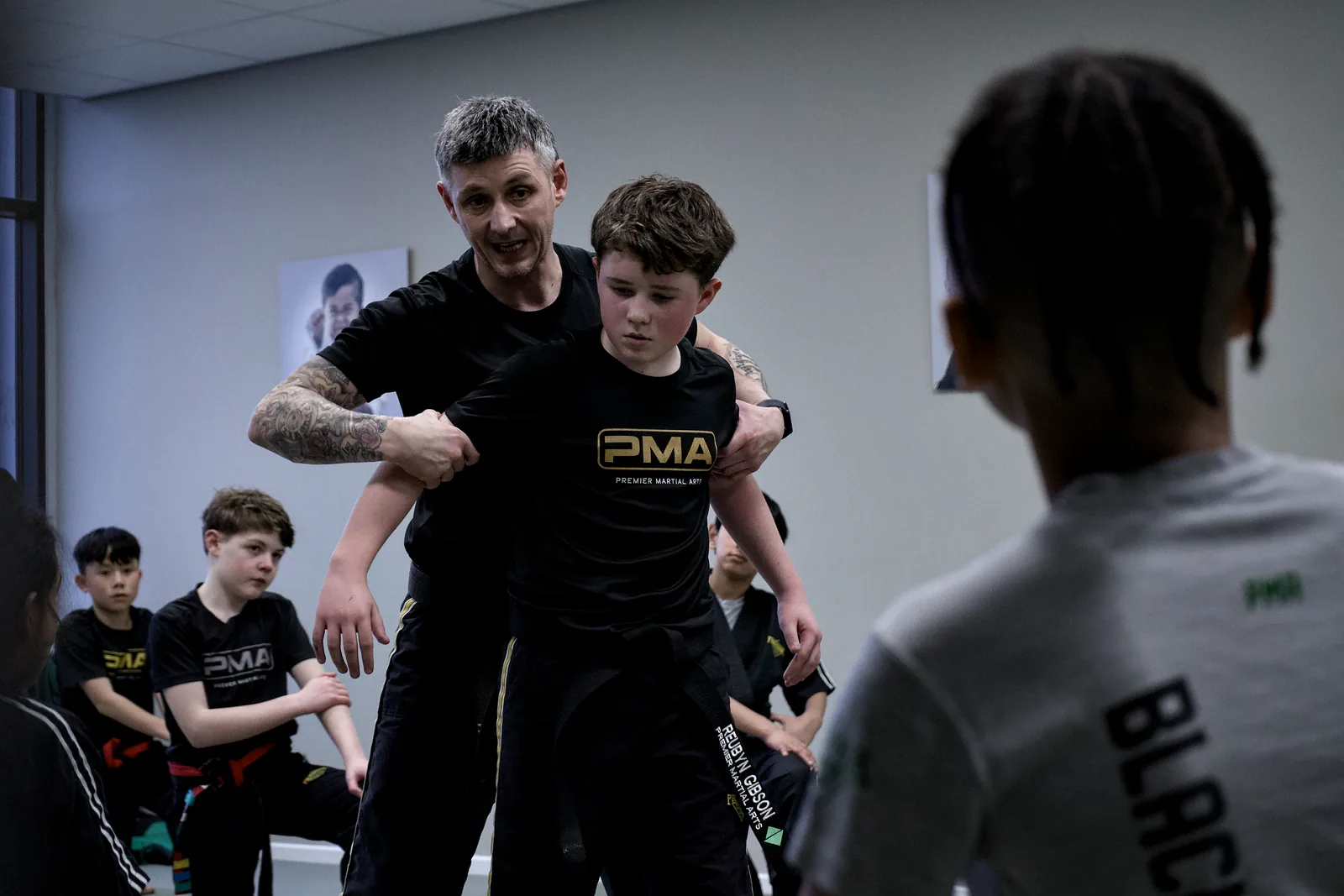 An instructor teaching a small group, the studio bright behind them