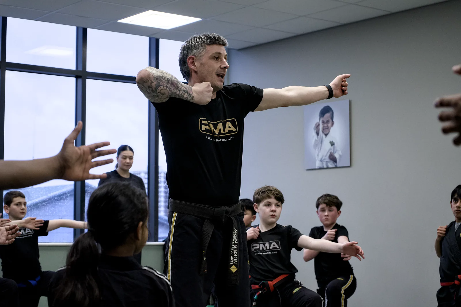 An instructor demonstrating a block to a group of children by the window