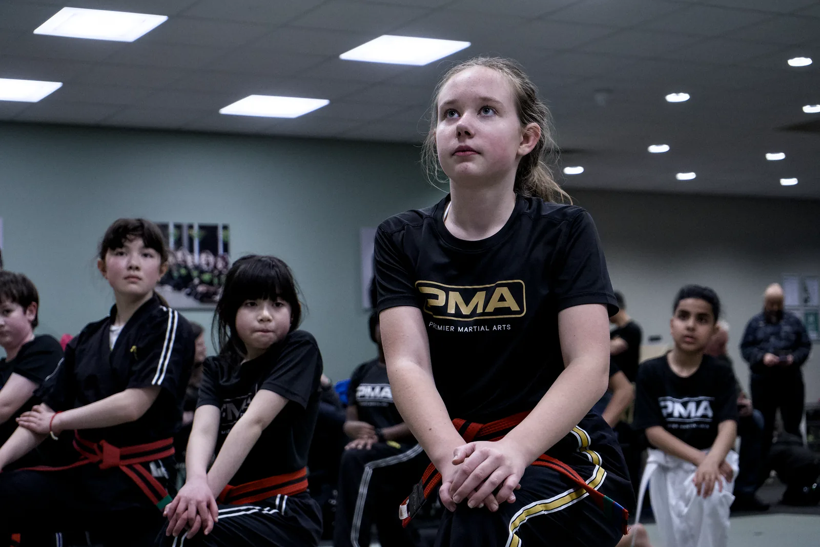 A row of children stood in a ready stance, watching the front of the class