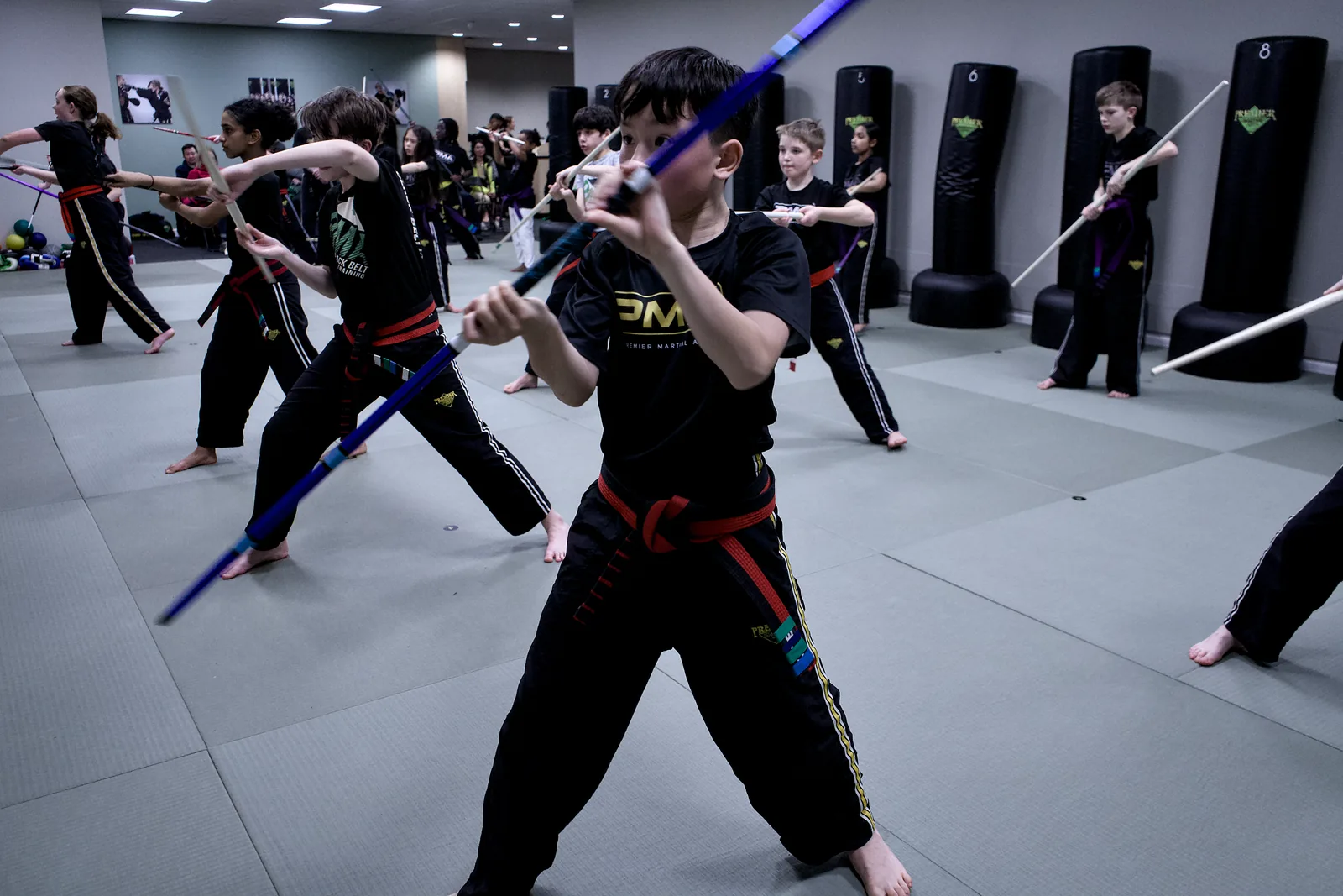 A group of children working a staff drill in formation