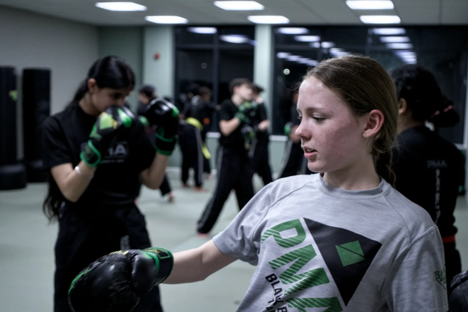 One student steadying a pad while another practises striking it