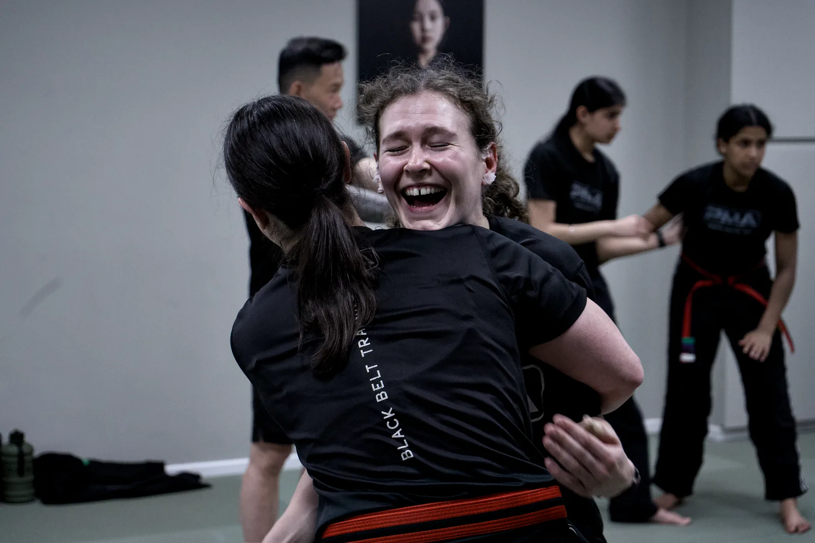 An adult student laughing mid-session with the rest of the class behind her