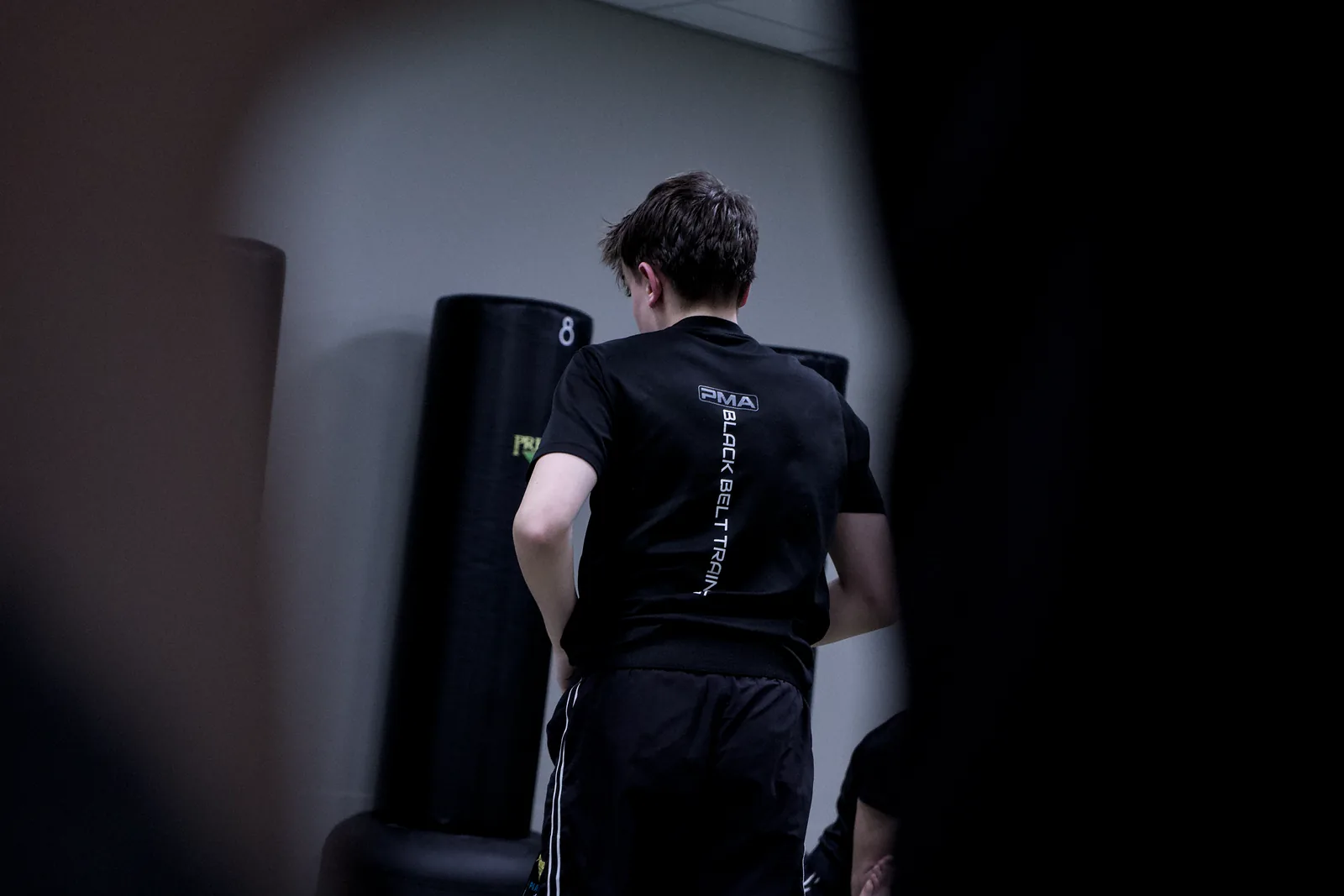 An adult student working a technique against the wall pads