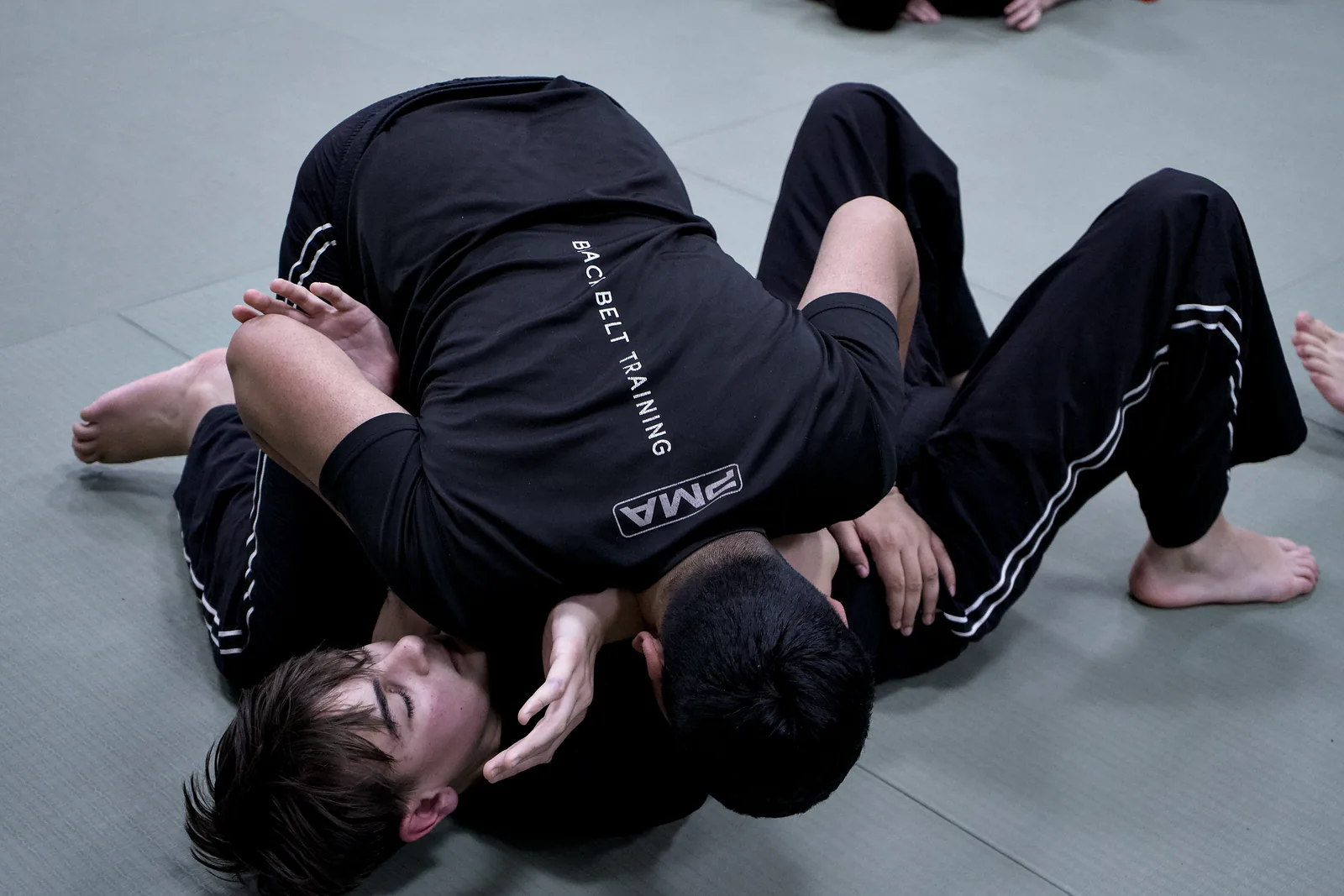 Two adults working on the ground, one controlling the other from the top