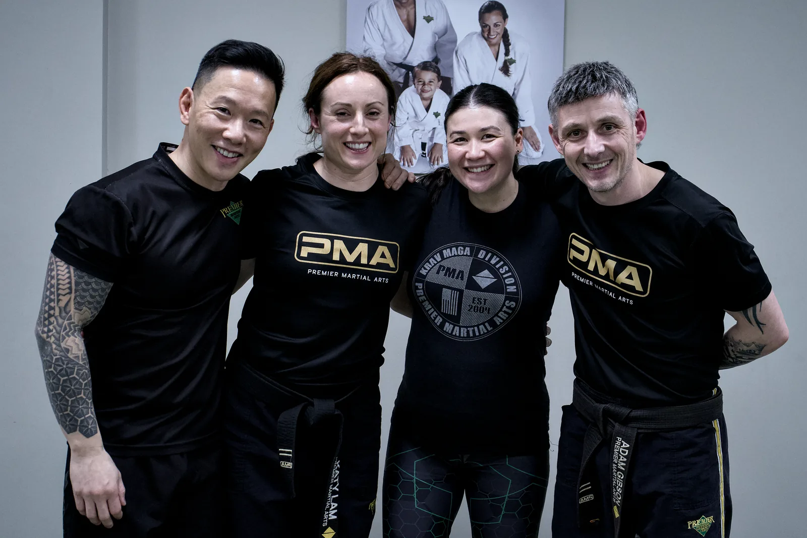 Four adult students stood together after a session, arms round each other